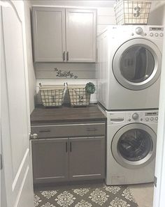 a washer and dryer in a small laundry room with gray cabinets, patterned floor tiles