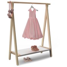 a pink dress and shoes are on a wooden shelf next to a pair of baby shoes