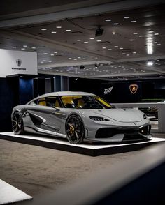 a silver sports car on display in a showroom