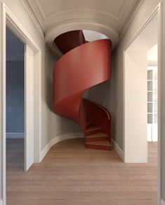 a red spiral staircase in an empty room