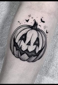 a black and white pumpkin tattoo on the arm