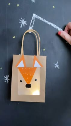 a hand holding a paper bag with a fox on it