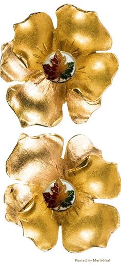 two golden flowers with leaves on them