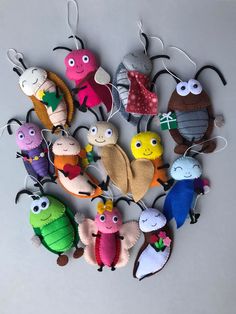 a group of small stuffed animals hanging from strings on a wall ornament in the shape of a circle