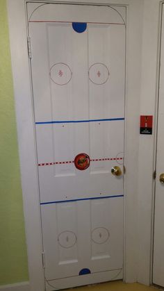 an ice hockey rink door is taped to the wall with blue tape and red circles on it