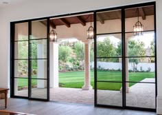 the inside of a house with glass doors and brick walkway leading to an outside patio