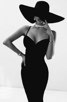 a woman in a black dress and hat