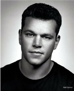 a black and white photo of a man with short hair wearing a t - shirt