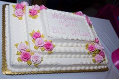 there is a wedding cake with pink flowers on the side and welcome home sign on top