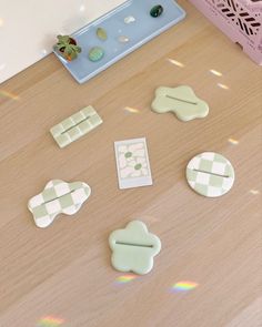 several pieces of plastic sitting on top of a wooden table next to a pink box