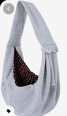 a gray bag with brown polka dots on the front and bottom, hanging from a hanger