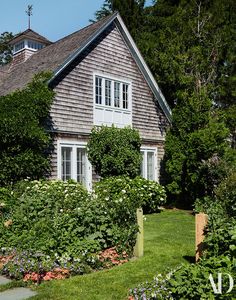 a house surrounded by lush green grass and flowers