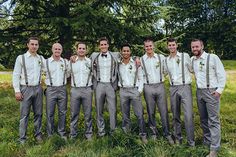 a group of men standing next to each other on top of a lush green field