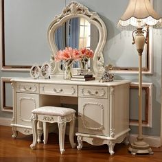 a white dressing table with mirror and stool