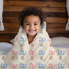 a young child wrapped in a blanket on top of a bed