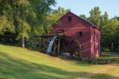 a red barn with a water wheel in front of it