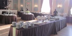 a long table is set up with plates and silverware for guests to eat at