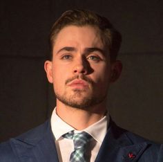 a man in a suit and tie looking off into the distance with his eyes wide open