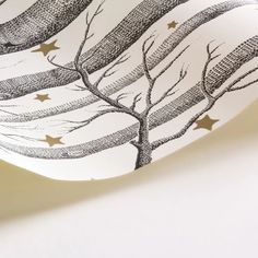 a paper plate with trees and stars on it