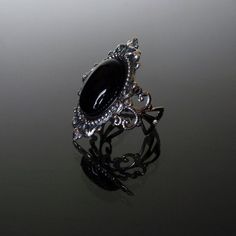 This ornate ring features a natural gemstone Black Onyx cabochon set in a beautifully decorative mount (measuring 35 x 25 mm) on a stunning filigree band. The Sterling silver plated filigree ring is adjustable so one size fits all. Nickel and lead free. This Sinistra Black Onyx filigree ring compliments perfectly our Sinistra lace choker which can be found in our Etsy store. The full Sinistra range of venise lace chokers and matching rings are available in Black Onyx, Black cameo, Sapphire blue, Vintage Gothic Wedding Rings, Gothic Oval Gemstone Jewelry, Oval Gemstone Gothic Jewelry, Oval Gothic Gemstone Jewelry, Gothic Oval Rings For Formal Occasions, Adjustable Gothic Onyx Jewelry, Gothic Adjustable Rings For Formal Occasion, Gothic Oval Gemstone Rings, Gothic Gemstone Rings With Oval Shape