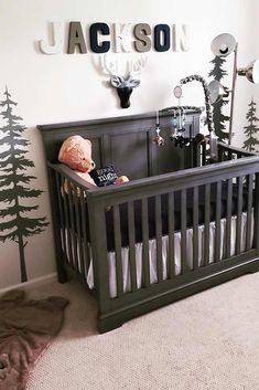 a baby's room with a crib and deer head on the wall