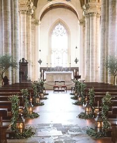 an image of a church with candles on the pews and flowers in front of it