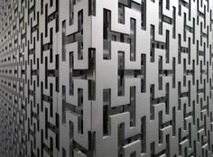 an abstract metal wall with many intersecting designs