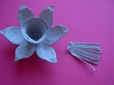 a paper flower and some forks on a pink surface