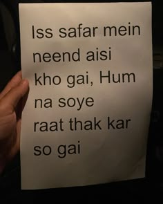 a person holding up a piece of paper with words written on it that read, less safar mein nend aisi kho gai, hum na soye raat thak kar soai