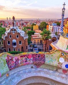 an artisticly designed bench overlooks the colorful cityscape in barcelona, spain