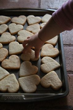 a child reaching for some heart shaped cookies