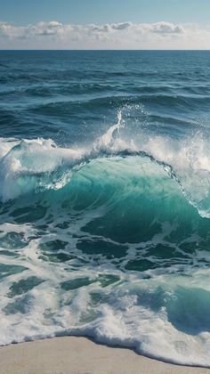 an ocean wave is breaking on the beach