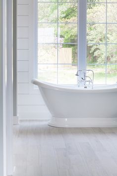 a white bath tub sitting next to a window