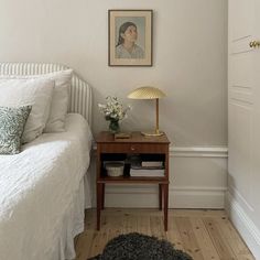 a bedroom with white walls and wood floors