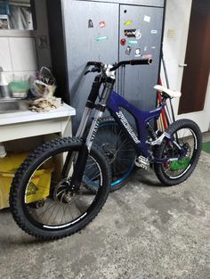 a blue bike parked in front of a refrigerator