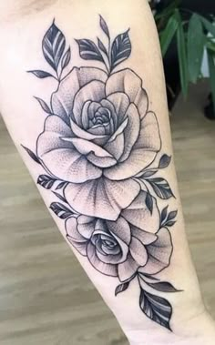 a black and white rose tattoo on the leg