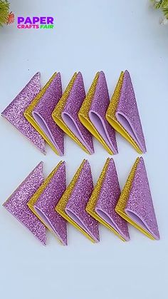 purple and yellow glittered paper napkins on a white surface with pine branches in the background