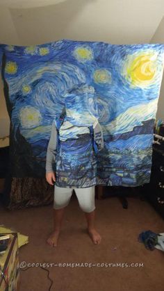 a man standing in front of a large piece of art that looks like the starry night