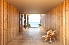 a wooden walkway leading to the beach with benches and chairs on either side, along with an ocean view