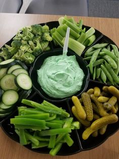 a platter filled with cucumbers, celery, and pickles