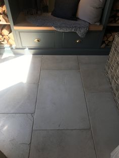 a kitchen with gray cabinets and white tile flooring in front of the counter top