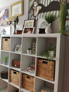 a shelf with baskets and pictures on it