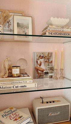 shelves with books, candles and pictures on them