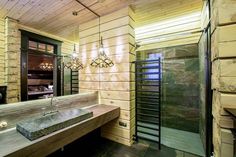 a bathroom with wooden walls and flooring next to a sink in front of a window