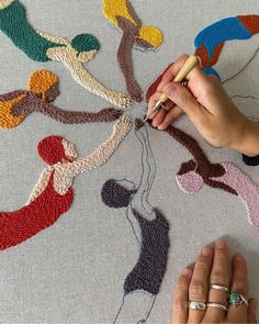 a woman is working on an art project with crocheted fabric and yarns