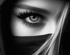 a woman's eyes are covered by a black veil