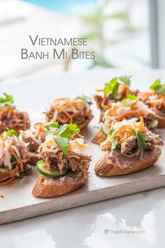 small sandwiches with meat and veggies are on a cutting board