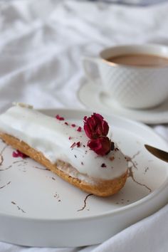 a piece of cake on a plate next to a cup of coffee