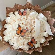 a bouquet of white roses with butterflies on them