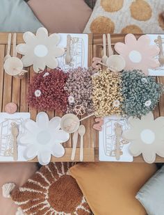 the table is covered with different colored flowers and place settings for guests to sit at